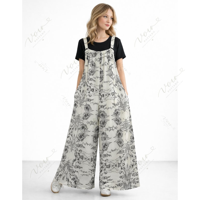 Puede incluir: Un mono sin mangas de pierna ancha con base color blanco roto y estampado floral bot&aacute;nico en negro. La prenda tiene cuello redondo, tirantes y una silueta holgada y fluida. Se lleva sobre una camiseta negra lisa de manga corta.