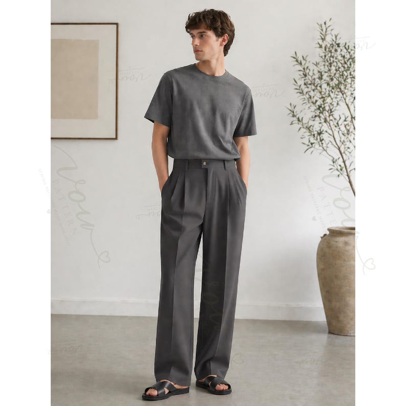 Op de afbeelding: Een antracietgrijs T-shirt met korte mouwen gecombineerd met een bijpassende antracietgrijze broek met hoge taille, plooien aan de voorzijde en rechte pijpen. De outfit wordt gecompleteerd door zwarte open sandalen aan de voeten.