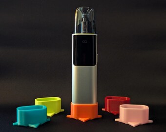 May include: A silver electronic device with a black display and a clear top cap, standing upright in an orange base. Four additional oval-shaped bases in blue, lime green, red, and light pink are arranged around the central device.