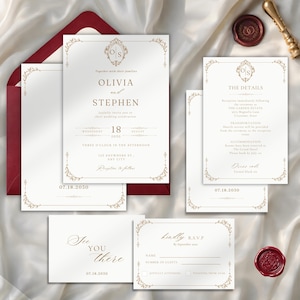 Op de afbeelding: Een trouwkaarten set bestaande uit witte kaarten met goudkleurige, sierlijke randen en tekst. Bevat een hoofduitnodiging voor Olivia en Stephen, een detailkaart, een RSVP-kaart en een klein kaartje, vergezeld van een dieprode envelop en lakzegel.
