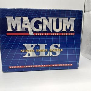 May include: A rectangular product box for a Magnum XLS series model engine. The box features a dark blue background with a white grid pattern, silver metallic lettering, and red horizontal bars containing white text about quality and warranty.
