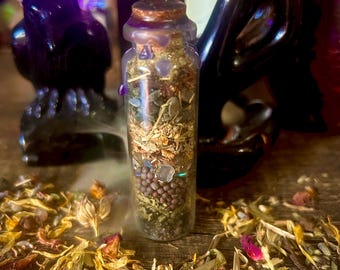 May include: A small, clear glass bottle filled with dried herbs, seeds, and crystals, sealed with a cork and purple wax. The bottle is surrounded by dried flowers, creating a mystical atmosphere. A black raven statue is in the background.