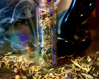 May include: A small glass bottle filled with dried herbs and flowers, sealed with a cork and purple wax. The bottle is surrounded by scattered petals and a dark background with wisps of smoke.