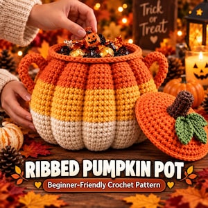 Puede incluir: Un recipiente de ganchillo con forma de calabaza y rayas horizontales de color naranja, amarillo y blanco. El recipiente tiene dos asas laterales y una tapa separada con un tallo marrón y hojas verdes. Está lleno de pequeños dulces envueltos.
