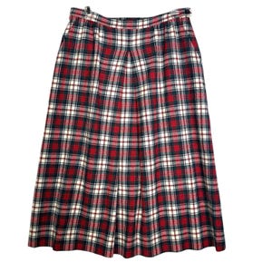May include: A red, white, and black plaid skirt with a pleated front. The skirt has a waistband with a button and zipper closure.