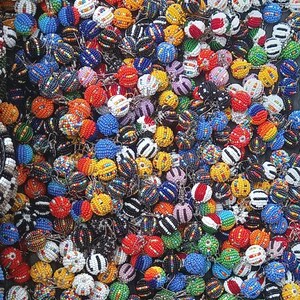 May include: A collection of colorful beaded sphere ornaments in various colors, including red, blue, yellow, and white. The spheres are densely packed together, creating a vibrant and textured display. The beads appear to be small and intricately arranged.