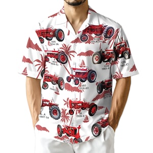 Puede incluir: Camisa blanca de manga corta con un estampado repetido de tractores rojos y siluetas de palmeras. Cada tractor está etiquetado con un número de modelo y un rango de años. La camisa tiene un cuello clásico.