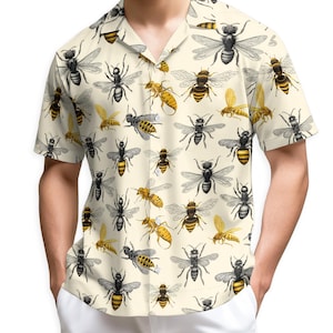 May include: Short-sleeved button-down shirt with a cream background and a repeating pattern of various bee illustrations in black, yellow, and gold. The shirt has a classic collar and is made of a lightweight fabric.