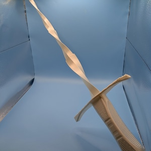 May include: A white 3D printed sword featuring a long, spiraling blade that tapers to a point. The hilt includes a crossguard and a textured grip with a repeating circular pattern. The entire object is constructed from a single piece of matte material.