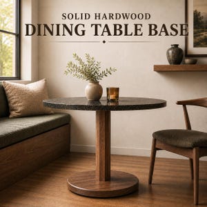 May include: A solid hardwood dining table base featuring a central vertical column and a circular floor plate. The table has a round, dark speckled top. Text at the top reads: SOLID HARDWOOD DINING TABLE BASE. The base is made of brown wood.