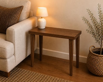 May include: A rectangular wooden side table with four straight legs and a dark brown finish. The table has a flat top surface and is positioned in a room, providing a stable base for items placed upon it, featuring a simple and functional design.