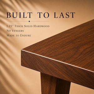 K&ouml;nnte beinhalten: Eine Ecke eines Tisches aus dunkelbraunem Massivholz mit glatter Oberfl&auml;che. Der Text lautet: BUILT TO LAST, 1.25" THICK SOLID HARDWOOD, NO VENEERS, MADE TO ENDURE. Die Holzmaserung ist auf der flachen Oberfl&auml;che und dem Tischbein sichtbar.