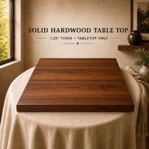 May include: A rectangular solid hardwood table top with a rich brown wood grain finish. The text "SOLID HARDWOOD TABLE TOP" and "1.25" THICK • TABLETOP ONLY" is printed above the object, indicating its material and thickness.