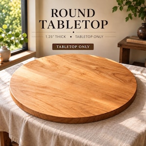 May include: A round wooden tabletop with a natural light brown grain finish. The text on the image reads ROUND TABLETOP, 1.25 INCH THICK, TABLETOP ONLY. This is a flat, circular piece of wood designed as a tabletop surface, measuring 1.25 inches thick.