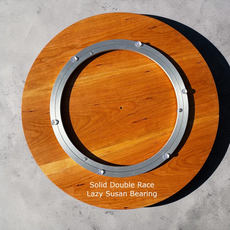 K&ouml;nnte beinhalten: Ein runder Lazy Susan-Drehteller aus Holz mit einem soliden Doppelrillen-Design. Die Holzoberfl&auml;che hat eine warme, r&ouml;tlich-braune Farbe, und ein silberner Metallring ist am Holz befestigt. Der Text "Solid Double Race Lazy Susan Bearing" ist aufgedruckt.