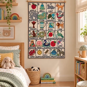 Puede incluir: Un tapiz rectangular que presenta una cuadrícula alfabética colorida con ilustraciones para cada letra de la A a la Z, incluyendo etiquetas como Apple, Bell, Cat, Dog, Elephant, Fish, Grapes, Hen, Ice-Cream, Jug, Kite, Lion, Monkey, Nest, Orange, Peacock, Queen, Rose, Swan, Tomato, Umbrella, Van, Watch, Xylophone, Yacht y Zebra.