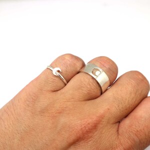 May include: Two silver rings, one with a crescent moon design and the other with a crescent moon cut-out.