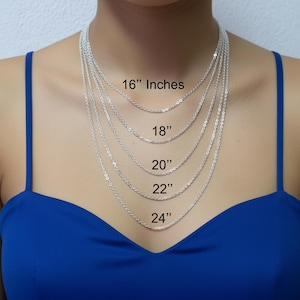 May include: Silver chain necklaces of varying lengths, displayed on a person. The lengths are labeled: 16 inches, 18 inches, 20 inches, 22 inches, and 24 inches. The person is wearing a blue top.