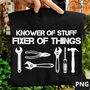May include: Black crew neck sweatshirt with the text "Knower of Stuff, Fixer of Things" in white. The design includes white illustrations of tools: a wrench, pliers, adjustable wrench, screwdriver, and hammer.