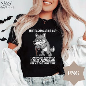 Pu&ograve; includere: T-shirt nero con la scritta "MULTITASKING AT OLD AGE: I CAN COUGH, BURP LAUGH FART SNEEZE AND PEE AT THE SAME TIME." Presenta un lupo dei cartoni animati con un bastone. La maglietta ha una grafica PNG.