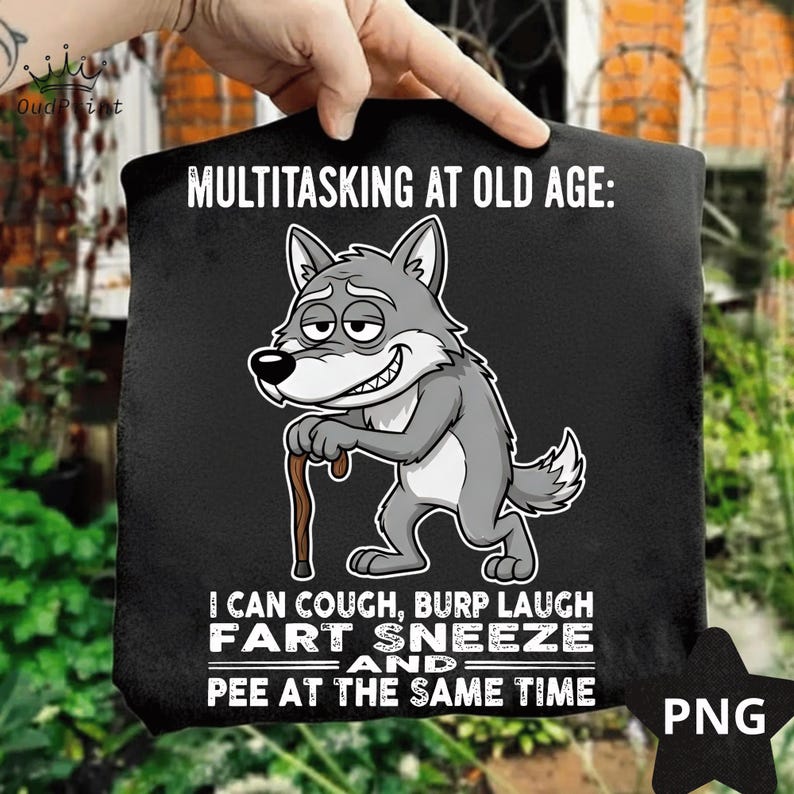 Pu&ograve; includere: T-shirt nero con un lupo dei cartoni animati e la scritta "MULTITASKING AT OLD AGE: I CAN COUGH, BURP LAUGH FART SNEEZE AND PEE AT THE SAME TIME." Un logo PNG &egrave; nell'angolo in basso a destra.