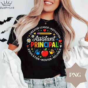 May include: Black t-shirt with a colourful graphic design for an Assistant Principal. The design includes the words "Assistant Principal" in a circular pattern with the words "Creator, Leader, Motivator, Educator, Mentor, Reliable". A pencil, apple, and handprints are also included.