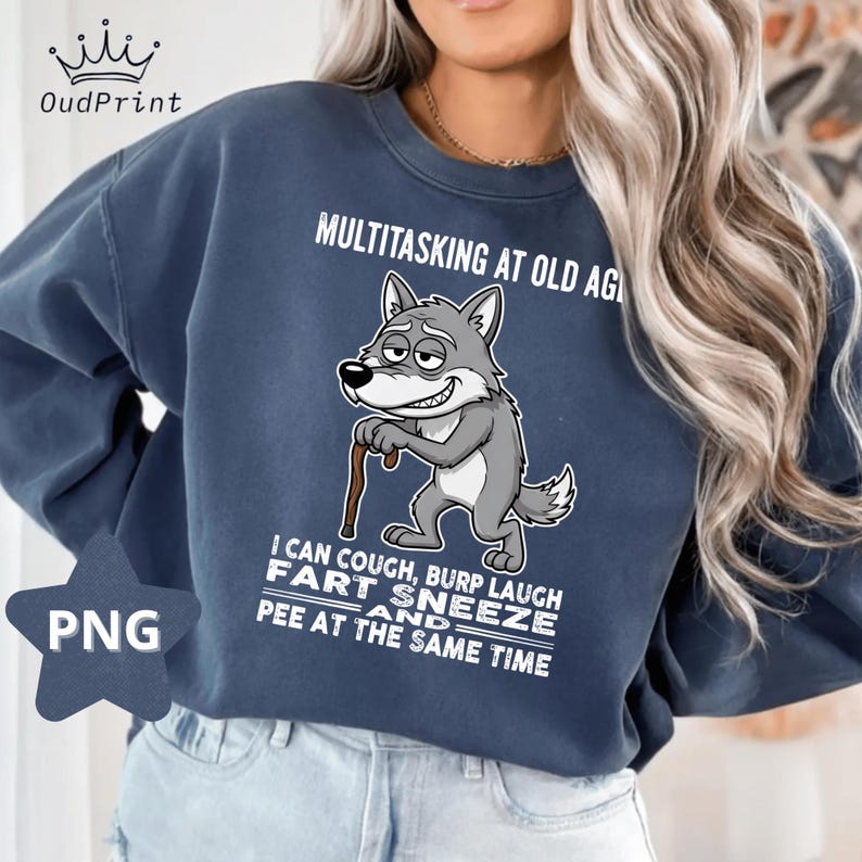 Pu&ograve; includere: Felpa blu navy con un lupo dei cartoni animati con un bastone e la scritta "MULTITASKING AT OLD AGE". Sotto, il testo recita "I CAN COUGH, BURP LAUGH FART SNEEZE AND PEE AT THE SAME TIME."