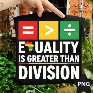 May include: Black t-shirt with the message "EQUALITY IS GREATER THAN DIVISION" in white text. The design includes a red square with two white horizontal lines, a yellow square with a white greater-than symbol, and a green square with a white division symbol.