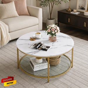 May include: Round coffee table with a white marble-look top and gold metal frame. The table has a lower glass shelf and is decorated with a vase of flowers, books, and a coffee cup. The table is on a light gray rug.