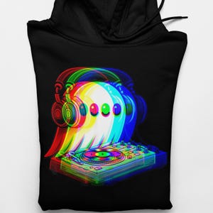 Puede incluir: Sudadera con capucha negra con un diseño gráfico 3D de un fantasma DJ. El diseño presenta un fantasma con auriculares y operando una mesa de mezclas, con vibrantes tonos rojos, verdes y azules. La sudadera tiene capucha y bolsillo delantero.