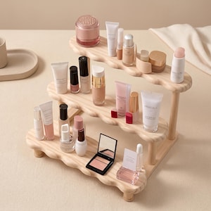 May include: A three-tiered wooden display stand holding various beauty products. The stand features a wavy edge design and is filled with skincare items, makeup, and nail polish. The products are in various colors and sizes, creating a visually appealing arrangement.