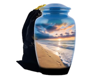 May include: A blue cremation urn with a scenic beach sunset design. The urn features a serene ocean view with footprints in the sand. A black velvet bag with a gold drawstring is next to the urn. The text "URN MEMORIAL" is visible.