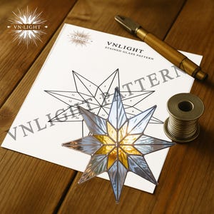 May include: A stained glass star with gold and clear glass panels, next to a pattern sheet and tools. The pattern sheet has the text "VN-LIGHT STAINED GLASS PATTERN". A spool of wire and a brass tool are also visible.