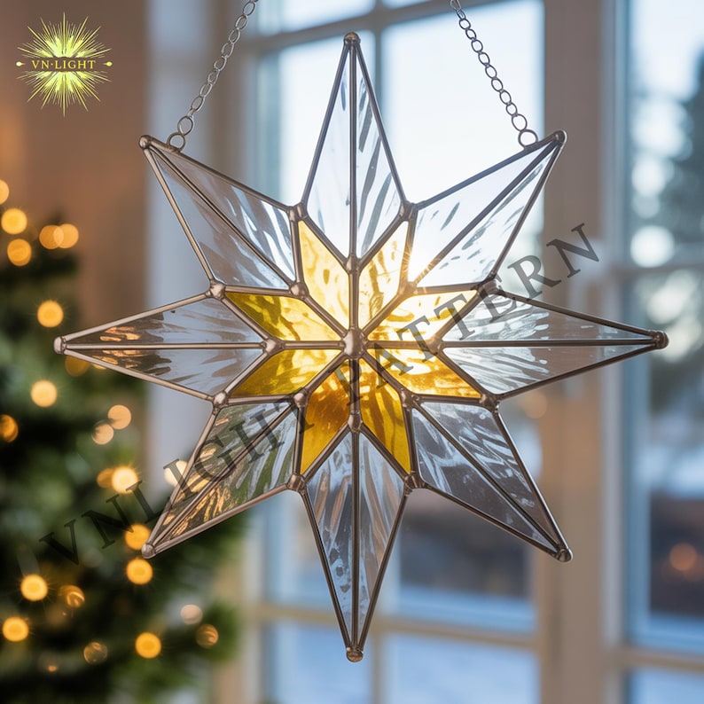 May include: A hanging stained glass star with a chain for display. The star has a clear and yellow color scheme, with a starburst pattern in the center. The star is made of glass and has a metal frame. The logo "VN-LIGHT" is in the upper left corner.