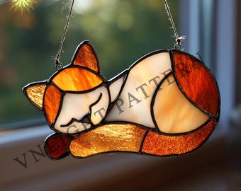 May include: Stained glass cat suncatcher in a sleeping pose. The cat is primarily white, orange, and amber, with black details. The suncatcher is hanging by a string. The text "VN-LIGHT" and "CAT PATTERN" are visible.