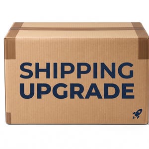 Könnte beinhalten: Ein rechteckiger Versandkarton aus brauner Pappe, der mit braunem Klebeband verschlossen ist. Auf der Vorderseite befindet sich der dunkelblaue Schriftzug SHIPPING UPGRADE in einer serifenlosen Schrift sowie ein kleines Raketensymbol.
