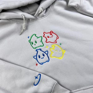 May include: A white ceramic mug with a black handle and the text "But First, Coffee" in a black, handwritten-style font. The mug is on a white surface.