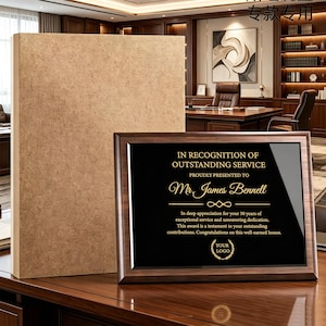May include: A rectangular wooden award plaque with a dark brown frame and a black center panel featuring gold text that reads: IN RECOGNITION OF OUTSTANDING SERVICE, PROUDLY PRESENTED TO Mr. James Bennell, and additional text regarding 30 years of service.