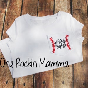 Könnte beinhalten: Weißes T-Shirt mit einer roten und weißen Baseballtasche mit einem Monogramm. Der Text "One Rockin Mamma" ist unter der Tasche aufgedruckt.