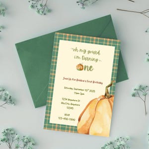 Op de afbeelding: Een herfst-thema verjaardagsuitnodiging met een aquarel pompoen illustratie. De uitnodiging bevat de tekst "oh my gourd, I'm turning one" en evenement details. Inclusief een groene envelop.