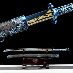 May include: An ornate sword with a blue and gold blade and handle. The handle features intricate dragon and wave designs. The sword is displayed on a wooden stand, showcasing its detailed craftsmanship and historical aesthetic.