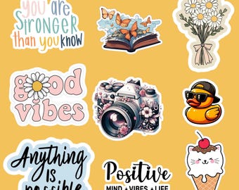 May include: A collection of colorful stickers on a yellow background. Designs include a camera with floral accents, a rubber duck wearing sunglasses, a bouquet of daisies, and text that reads "You are stronger than you know."