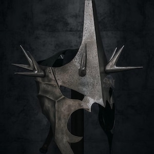May include: A detailed, metallic helmet with a tall, pointed central spike and multiple smaller spikes. The helmet has a textured, aged appearance, with intricate details and a dark, shadowy background.