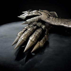 May include: A detailed, metallic claw gauntlet with articulated segments and sharp, pointed talons. The silver-toned armor features intricate detailing and a dark background, creating a dramatic effect. This fantasy-themed accessory is designed for cosplay or display.
