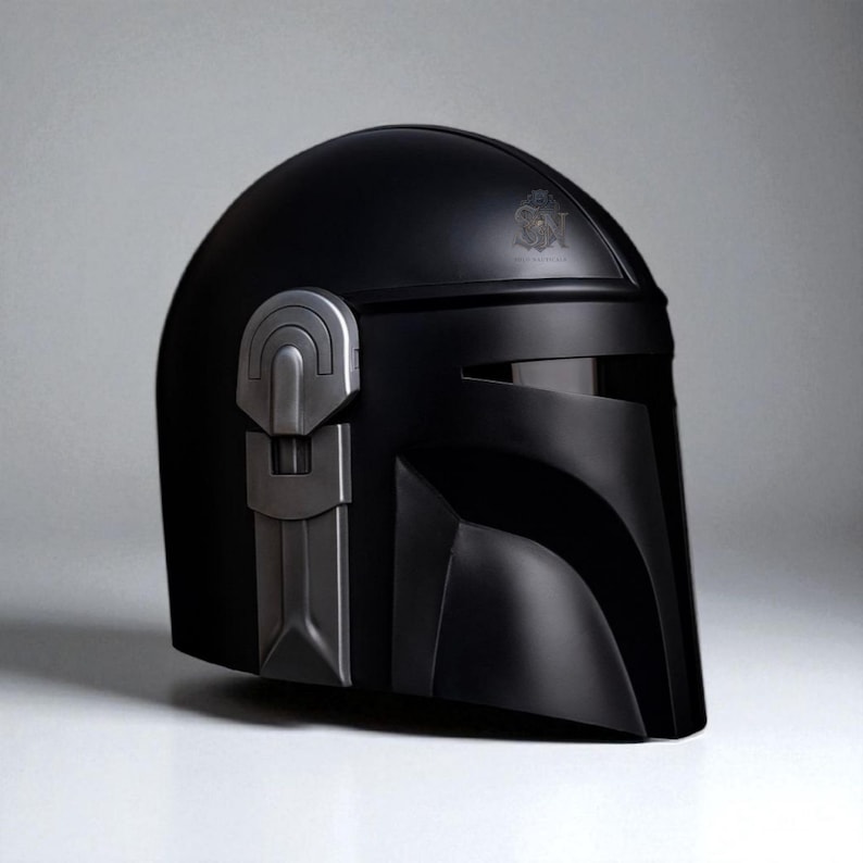 May include: A black helmet with a silver-colored accent on the left side. The helmet has a visor and a smooth, matte finish. The design is reminiscent of a sci-fi or space-themed aesthetic.