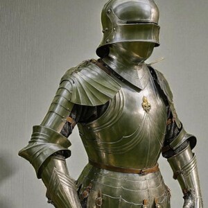 May include: A full suit of polished steel armor, including a helmet, chest plate, and articulated limbs. The armor features intricate detailing and a brown leather belt. The helmet has a visor, and the gloves are also made of steel.