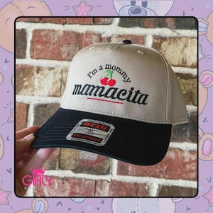 May include: A beige and black baseball cap with the text "I'm a mommy mamacita" embroidered in black and red. The cap features a curved brim and a classic fit, perfect for casual wear.