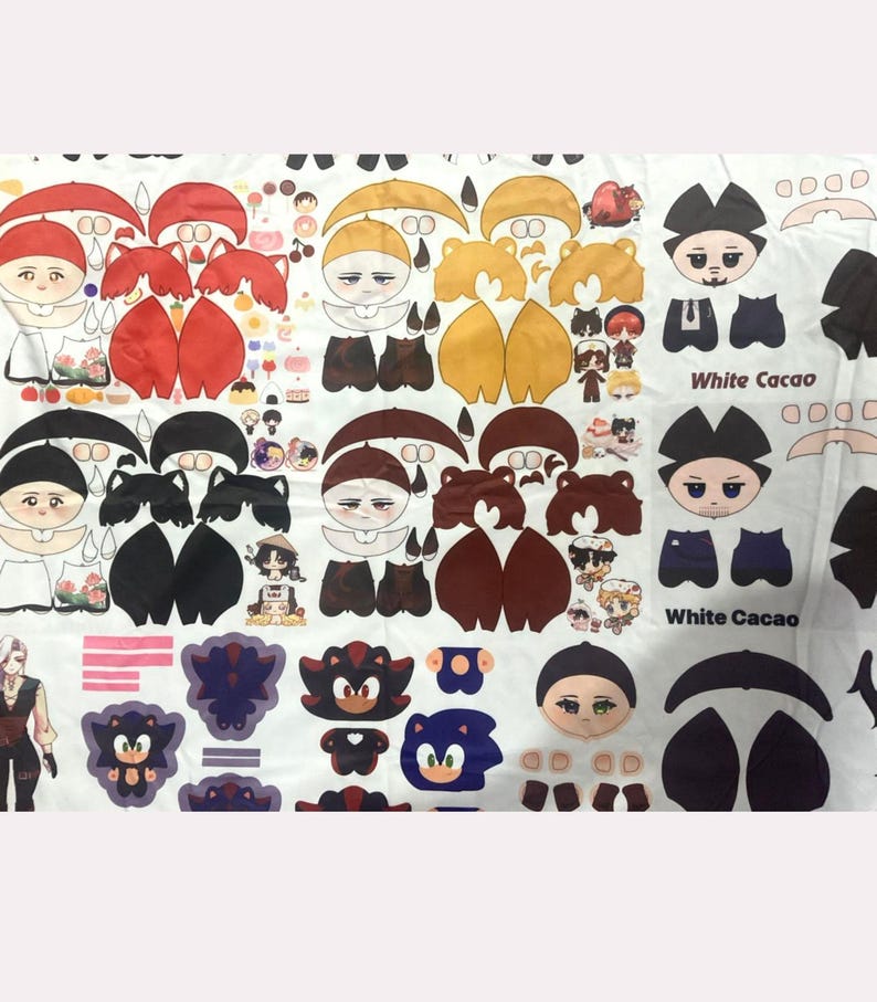 K&ouml;nnte beinhalten: Wei&szlig;er Stoff mit Ausschnitten von Zeichentrickfiguren bedruckt. Die Designs umfassen Figuren mit Regenschirmen, B&auml;ren und Sonic the Hedgehog. Die Ausschnitte sind in Rot, Braun und Blau gehalten. Der Text "White Cacao" ist ebenfalls sichtbar.