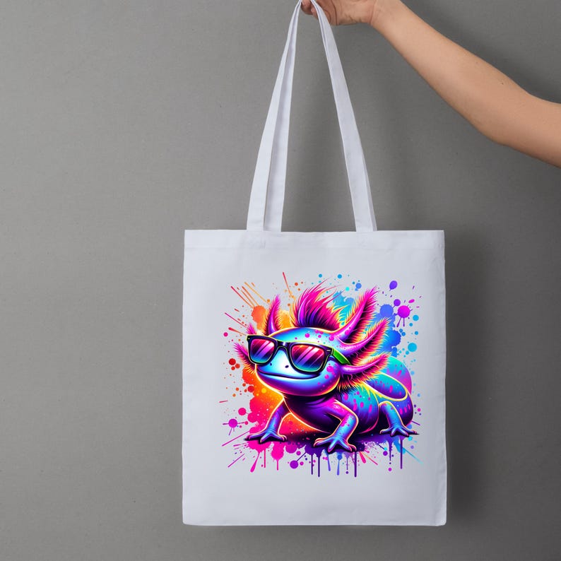 Pu&ograve; includere: Borsa tote bianca con un'illustrazione colorata di un axolotl con occhiali da sole. L'axolotl &egrave; raffigurato in vivaci tonalit&agrave; di blu, viola, rosa, arancione e verde, con schizzi di vernice. La borsa ha manici bianchi.