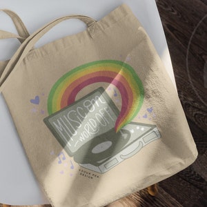 May include: A beige tote bag with a rainbow and a record player illustration. The text on the record player says "Music on - world off".